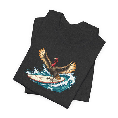 Dark gray surfing turkey Thanksgiving T-shirt featuring a teal wave and vintage-inspired island artwork folded