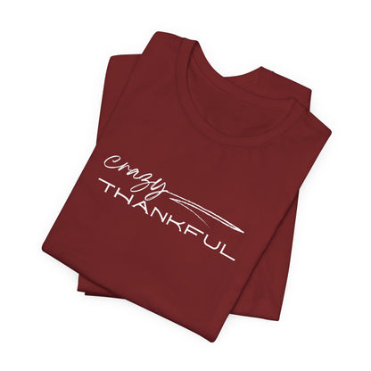 A folded maroon Crazy Thankful graphic t-shirt by Global Village Kailua
