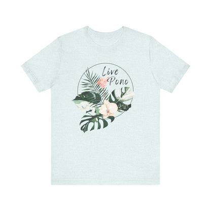A light heather blue short-sleeve crewneck t-shirt featuring a circular tropical graphic on the chest with green leaves, a pink flower, and the words 'Live Pono' in black script.