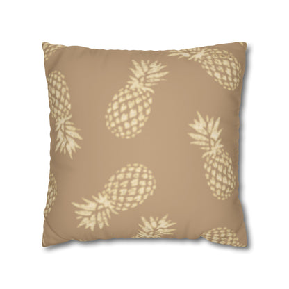 A square throw pillow featuring a beige and cream pineapple pattern on a solid tan background, shown against a plain white background.