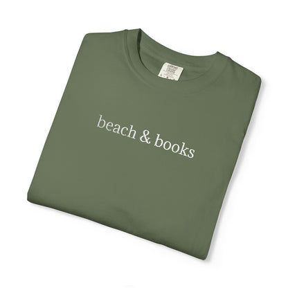 A folded green comfort colors tee with 'beach & books' embroidered in white