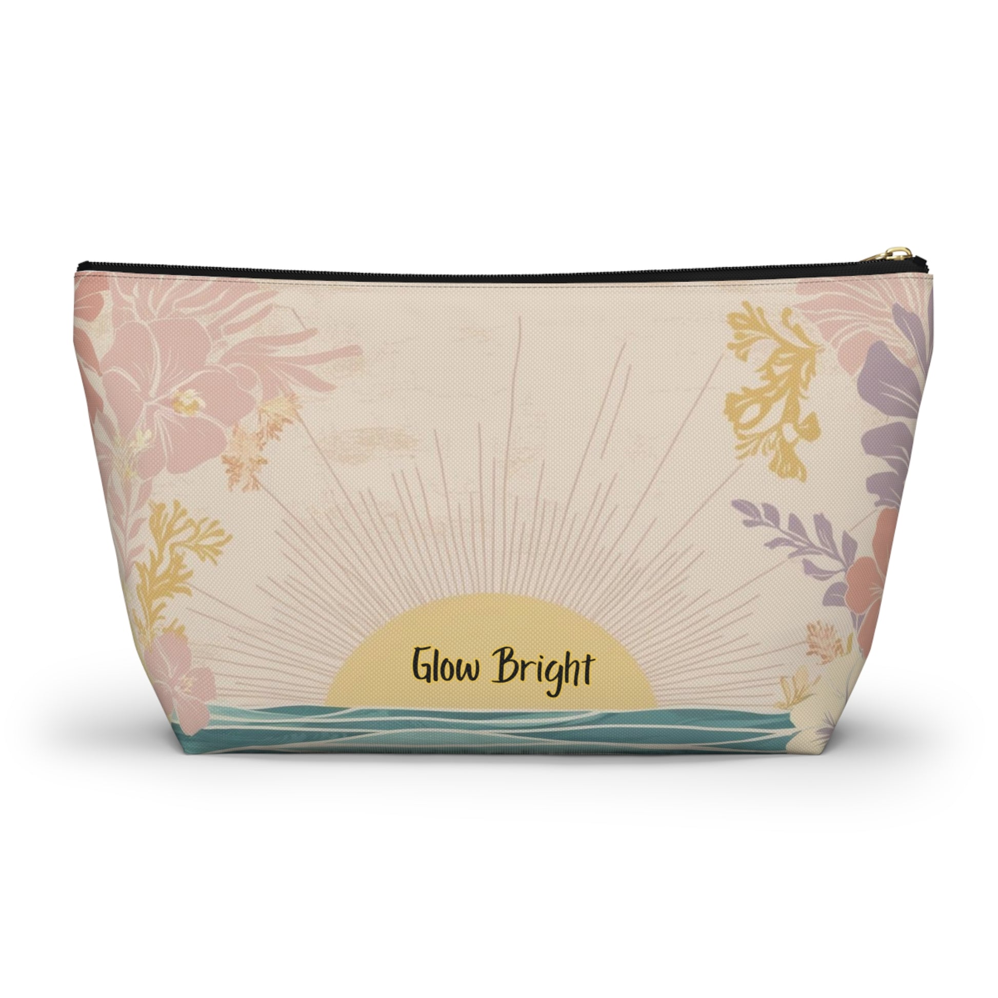 A rectangular zippered pouch with a tropical sunset print, featuring pink and purple flowers, a yellow sunburst, and the text 'Glow Bright' on a cream background.