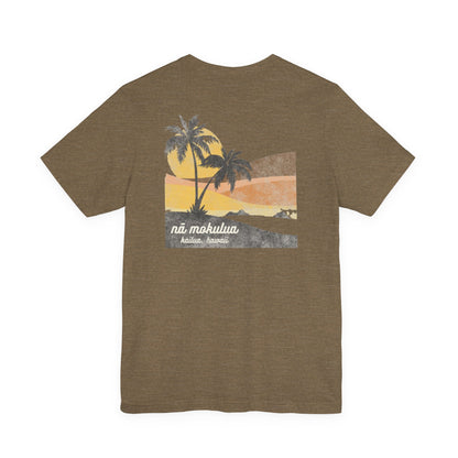 A heather olive short-sleeve t-shirt with a vintage-style graphic on the back depicting two palm trees against a yellow and orange sunset, with the text 'ná makulua' and 'Kailua, Hawaii!' printed below.