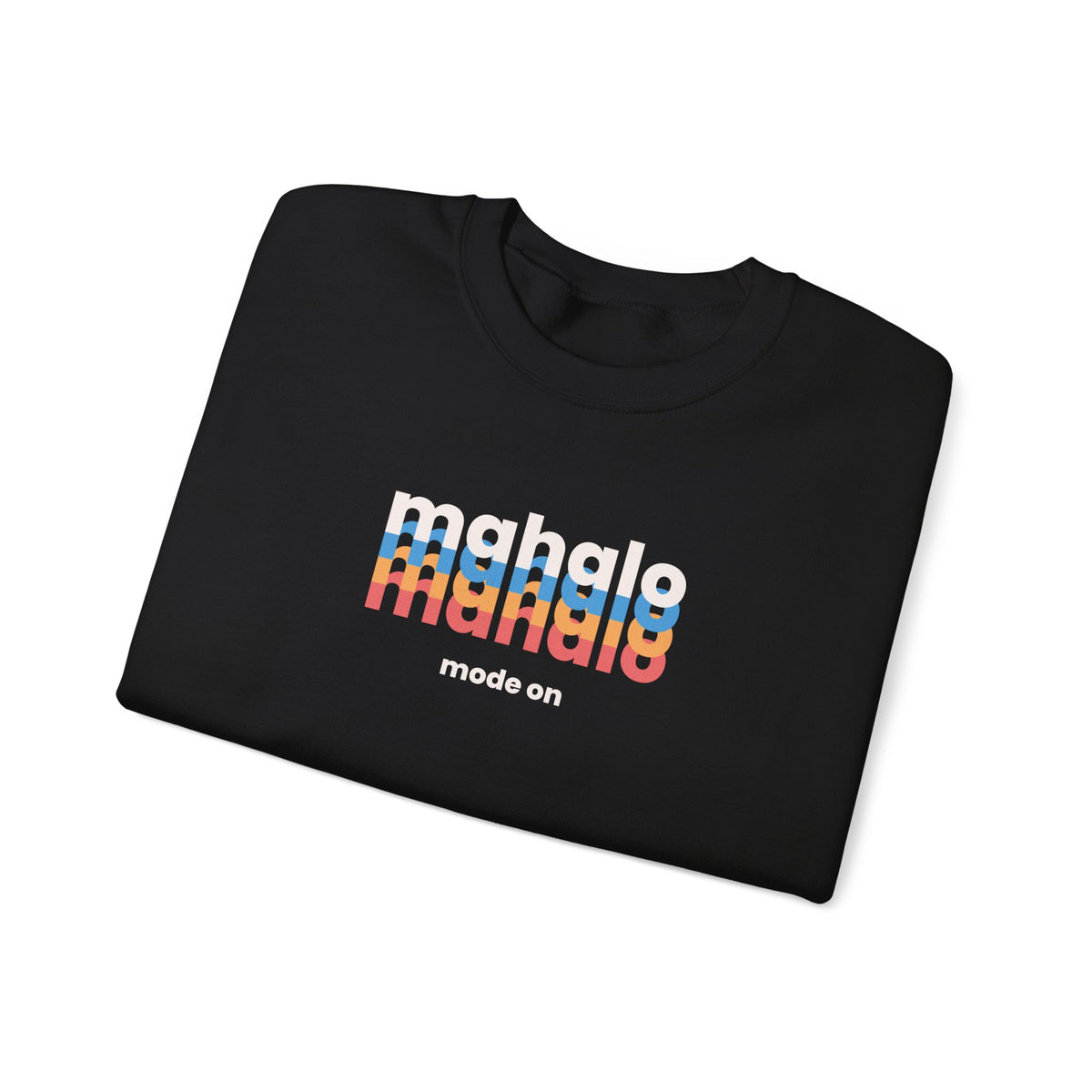 A folded black t-shirt with a colorful retro-style graphic reading 'mahalo mode on' on the front, displayed on a clean white background.