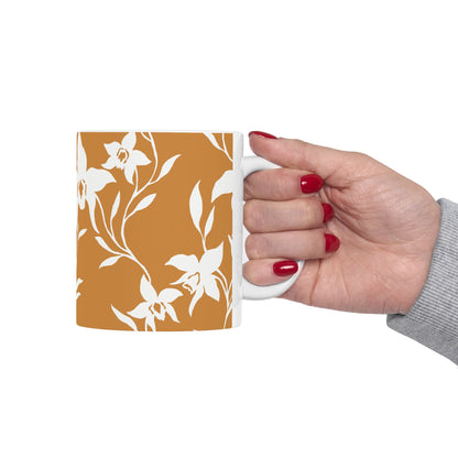 A hand holding an Orchid Caramel coffee mug with white tropical orchid print by Global Village Kailua
