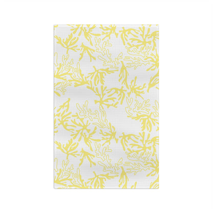 A rectangular white dish towel or tea towel featuring a repeating yellow coral or seaweed pattern, shown flat against a solid white background.