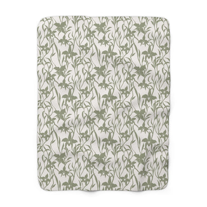 Sage green orchid-and-leaf print sherpa fleece blanket with a warm white background and rounded corners.