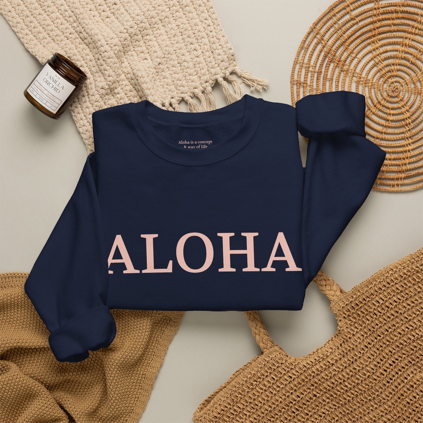 Navy sweatshirt folded with text 'ALOHA' in light pink