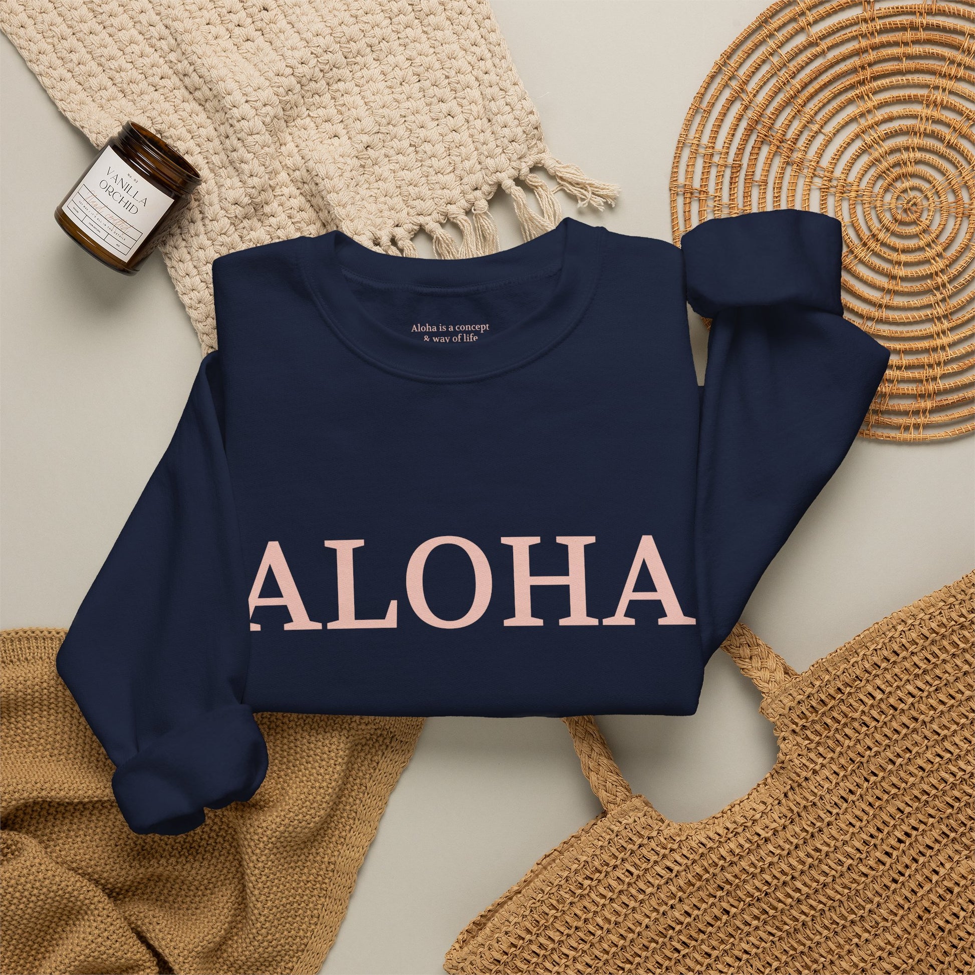 Navy sweatshirt folded with text 'ALOHA' in light pink