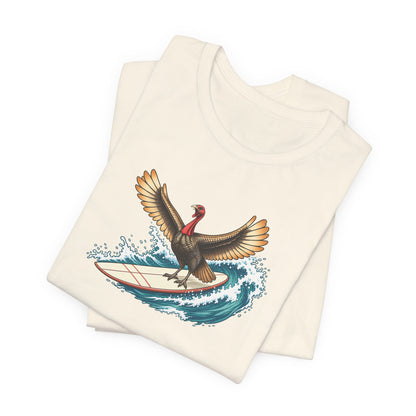 Natural color Turkey graphic T-shirt featuring a turkey riding a surfboard on a blue ocean wave folded.