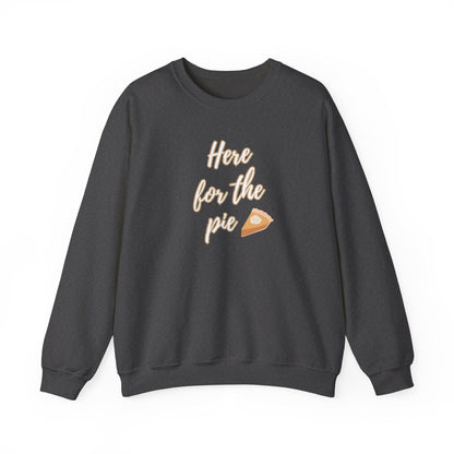 A dark charcoal gray crewneck sweatshirt featuring a graphic print on the front that reads 'Here for the pie' in a light beige script font, accompanied by a small slice of pie illustration.
