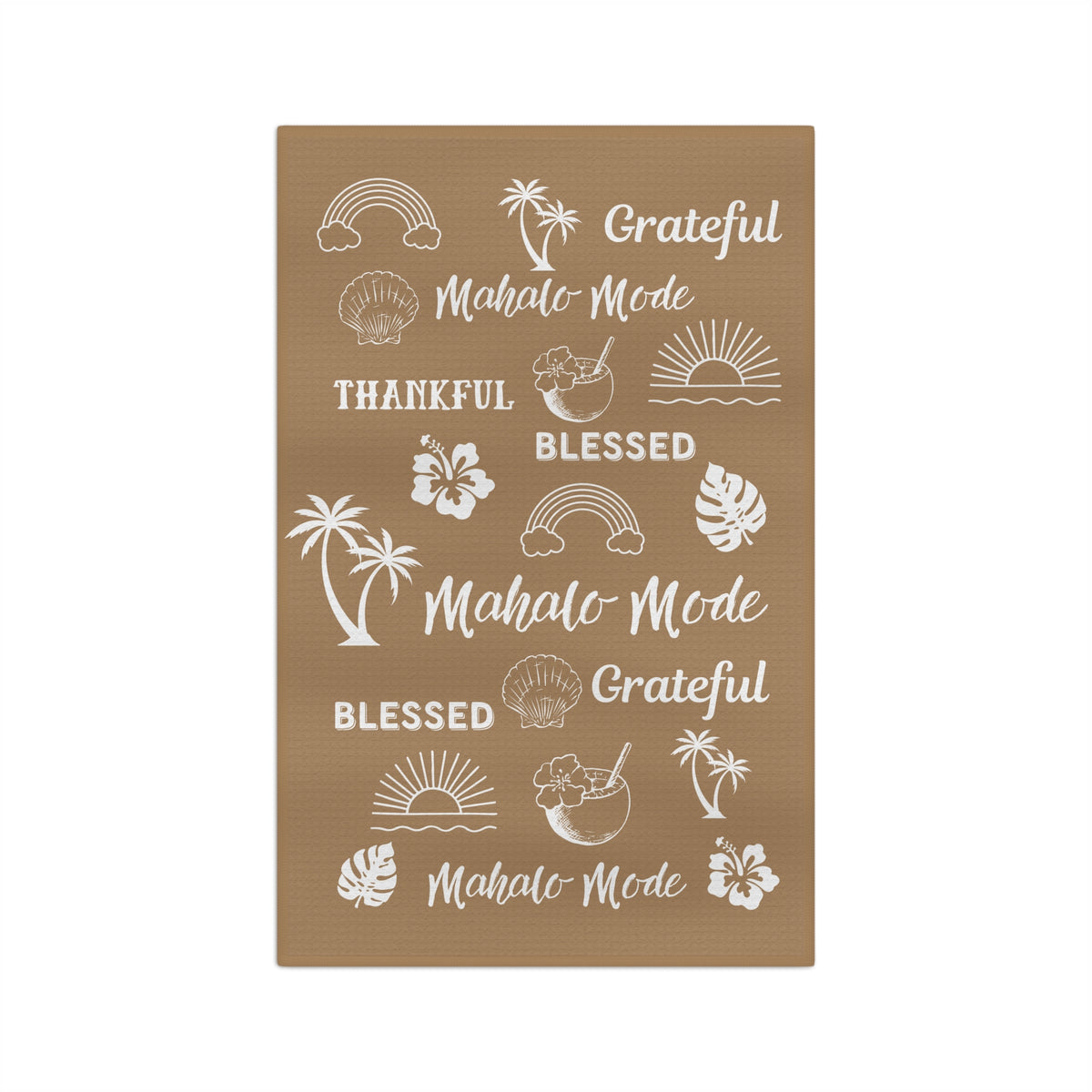 A tan kitchen towel with white tropical-themed illustrations and phrases including rainbows, palm trees, hibiscus flowers, seashells, and repeated text reading 'Grateful Mahalo Mode' and 'Blessed.'.