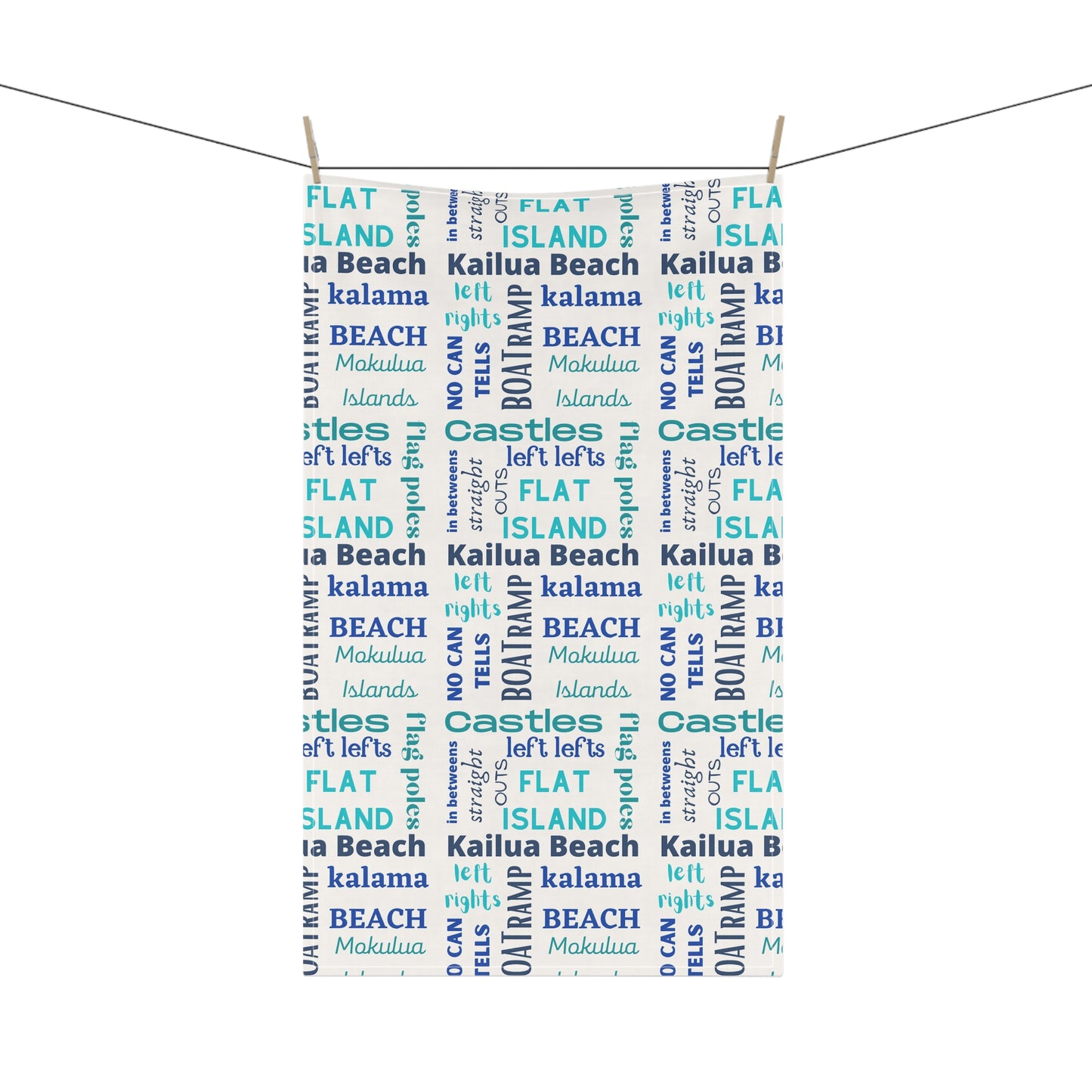A tea towel featuring a repeating pattern of words like 'FLAT ISLAND', 'CASTLES', 'KALAMA BEACH', 'Kailua Beach', 'BOAT RAMP', and 'MOKOLUA ISLANDS' in blue, teal, and navy on a white background.