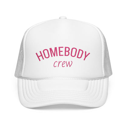 A white trucker hat with pink embroidered text reading 'HOMEBODY crew' on the front panel, shown against a plain white background.