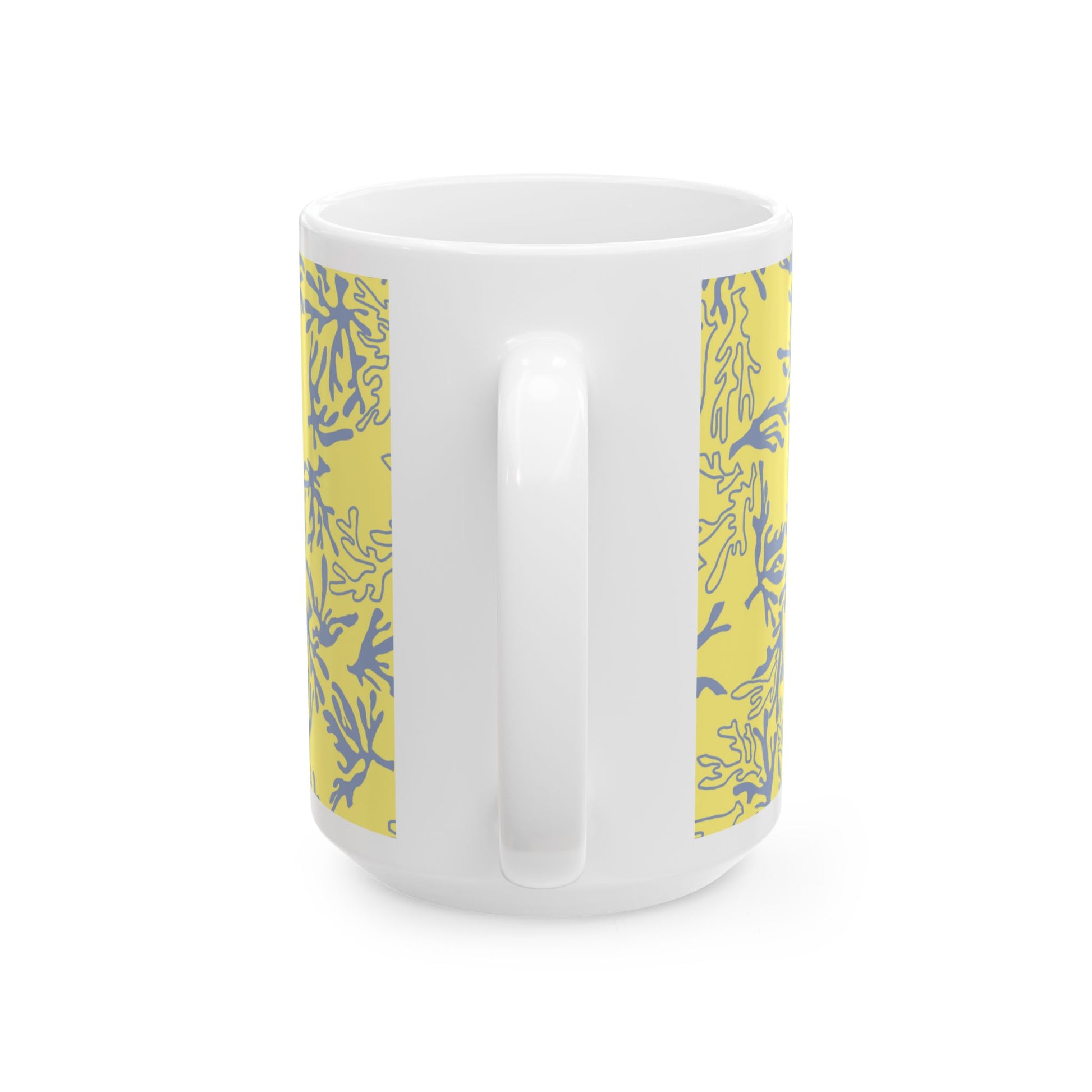 A white ceramic mug with a yellow and blue coral pattern printed on both sides, shown against a plain white background.