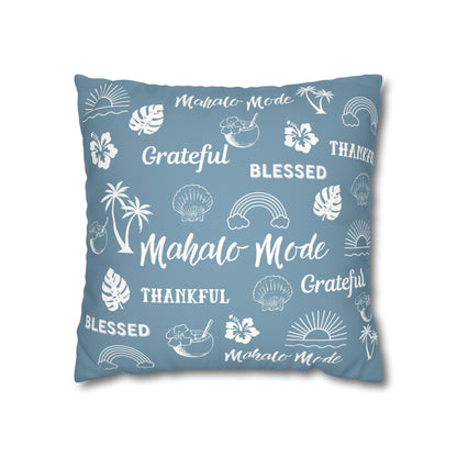 A square throw pillow in a dusty blue color, printed with white tropical-themed illustrations and words including 'Mahalo Mode', 'Grateful', 'Blessed', and 'Thankful'.