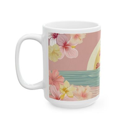 A white ceramic mug featuring a tropical floral wrap design with pink hibiscus flowers, yellow flowers, a pink sky, and a teal water stripe, shown on a plain white background.