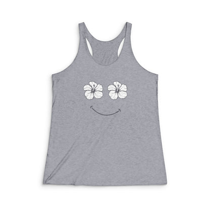 A heather gray racerback tank top featuring a white graphic of two hibiscus flowers forming eyes and a curved smile on the chest, displayed against a plain white background.