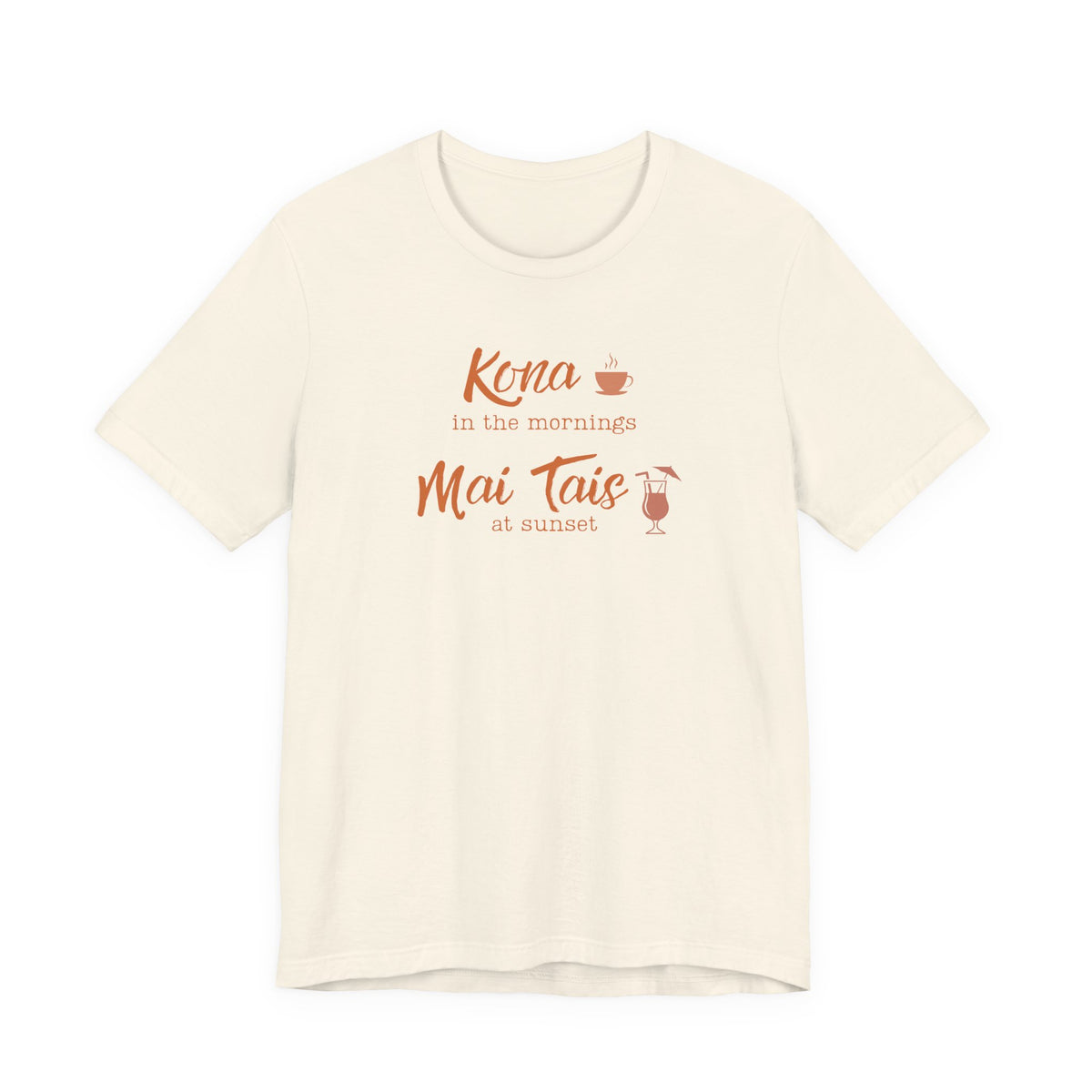 An off-white short-sleeve crewneck t-shirt with a coral orange graphic on the chest that reads 'Kona in the mornings Mai Tais at sunset' with small coffee and cocktail illustrations.