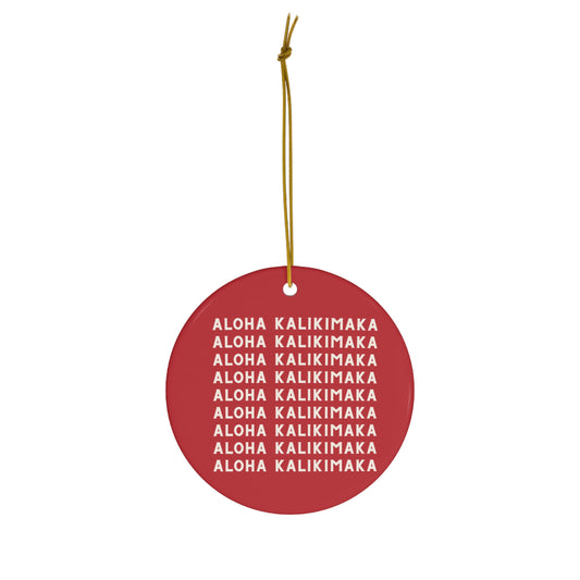 Red ceramic Christmas ornament featuring repeating cream Aloha Kalikimaka lettering on both sides.