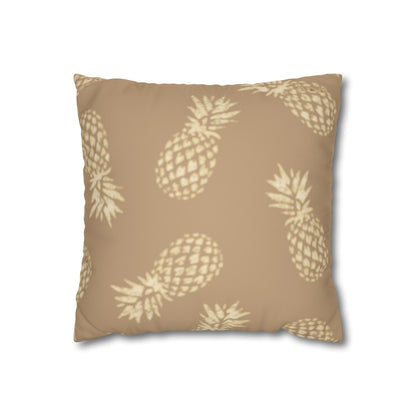 A square throw pillow featuring a repeating pattern of light beige pineapples on a warm tan background, shown against a plain white studio background.