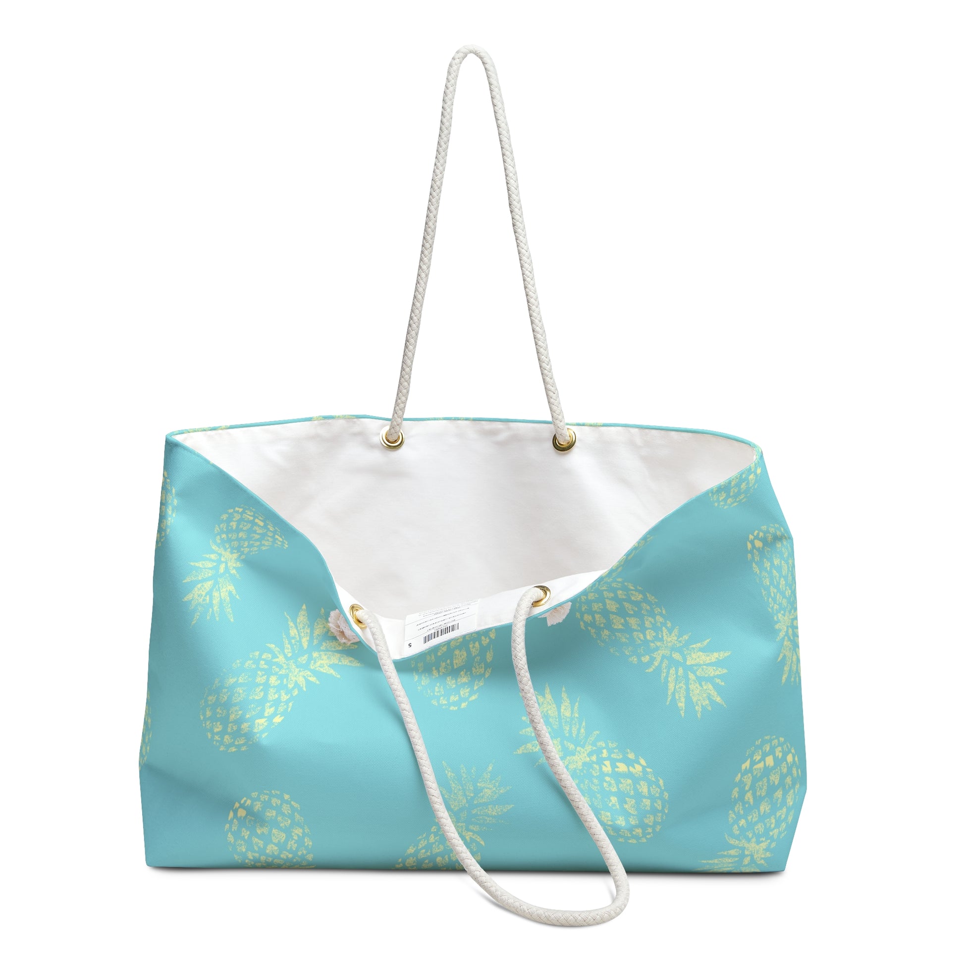 A turquoise blue tote bag with a yellow pineapple pattern, featuring a white rope handle and a white interior lining.