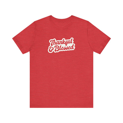 A heather red short-sleeve t-shirt with 'Thankful & Blessed' printed in white cursive text across the chest, displayed on a solid white background.