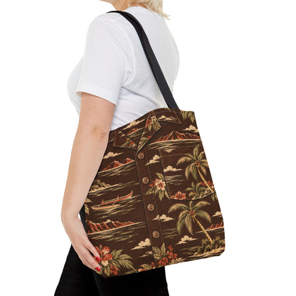 A woman wearing a white t-shirt and black pants carries a brown canvas tote bag with a tropical button-up shirt print featuring palm trees, canoes, and mountains. The bag has a black shoulder strap and is shown against a plain white background.