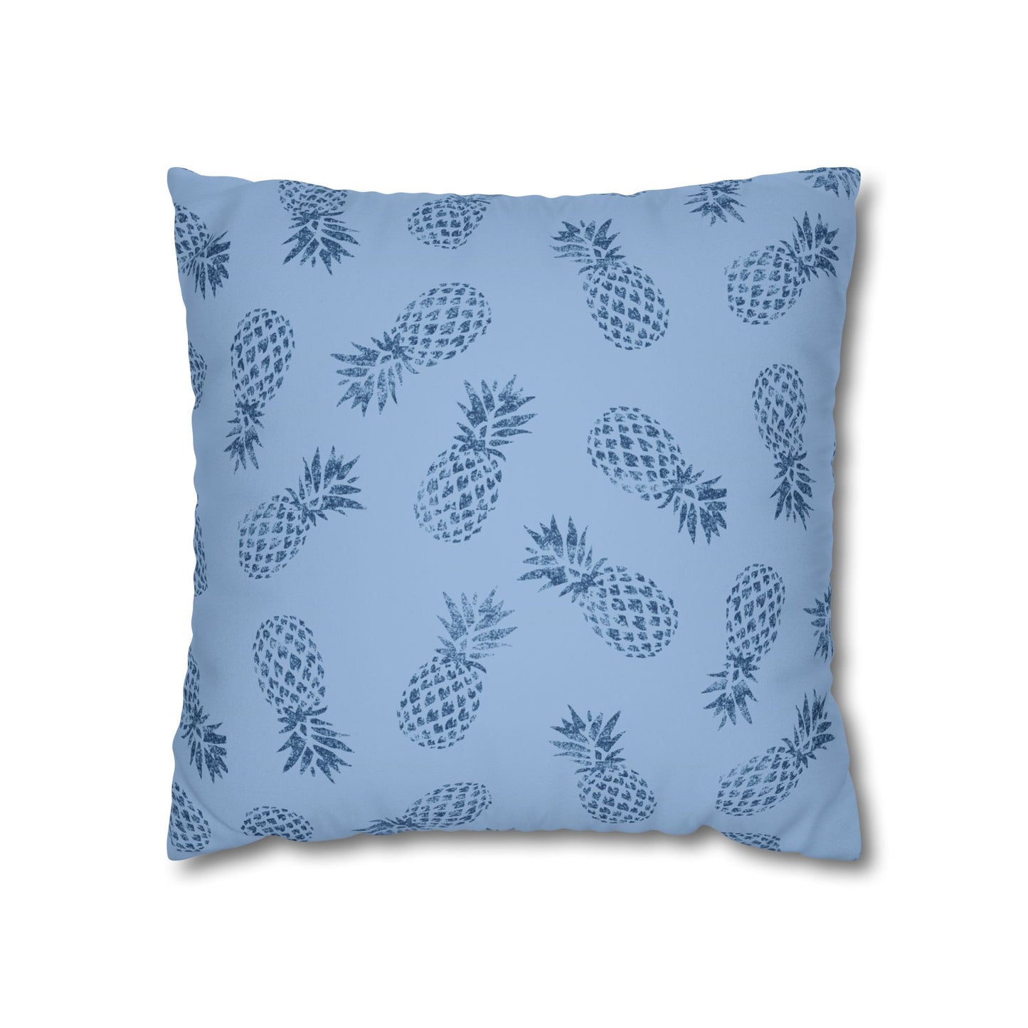 A square throw pillow featuring a repeating dark blue pineapple pattern on a light blue background, shown against a plain white studio backdrop.