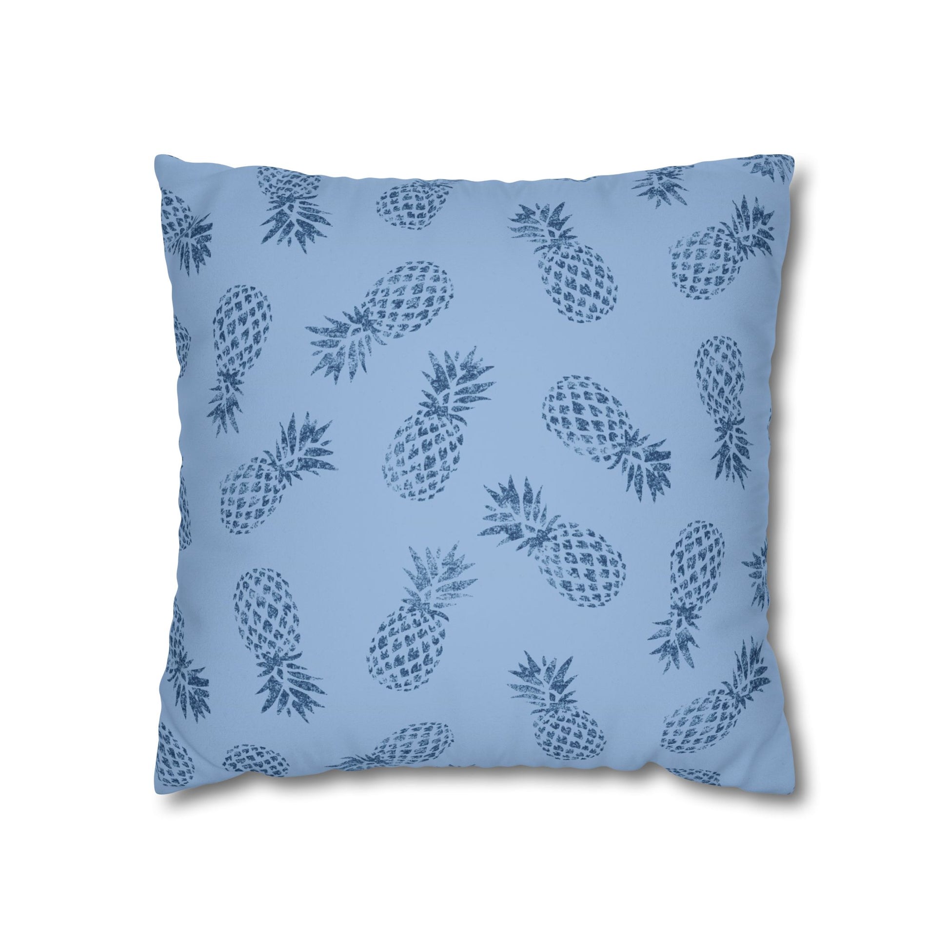 A square throw pillow featuring a repeating dark blue pineapple pattern on a light blue background, shown against a plain white studio backdrop.