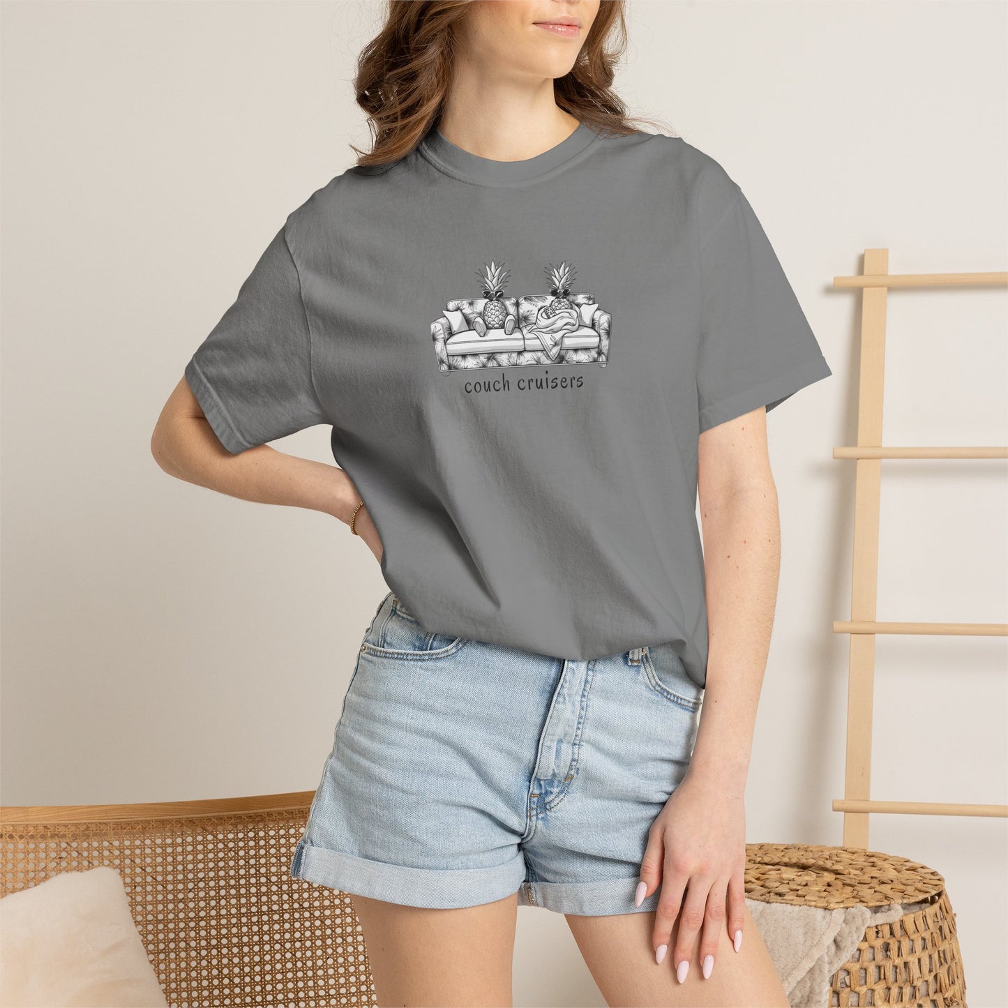 Woman wearing grey Couch Cruisers Comfort Colors graphic tee with denim shorts