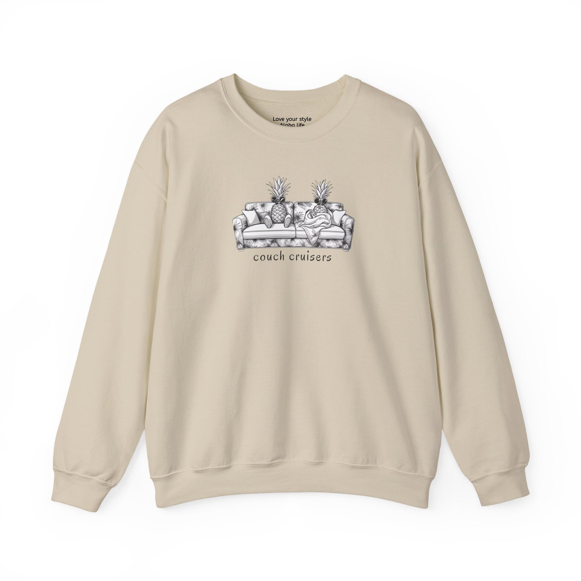 A beige crewneck sweatshirt featuring a black and white line art graphic of a couch with pineapples and the text 'couch cruisers' on the chest, displayed against a solid white background.