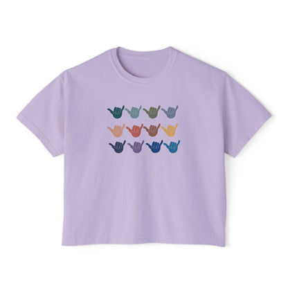 An lavender crop short-sleeve t-shirt with a graphic of twelve shaka signs in various colors arranged in three rows, displayed on a clean white background.