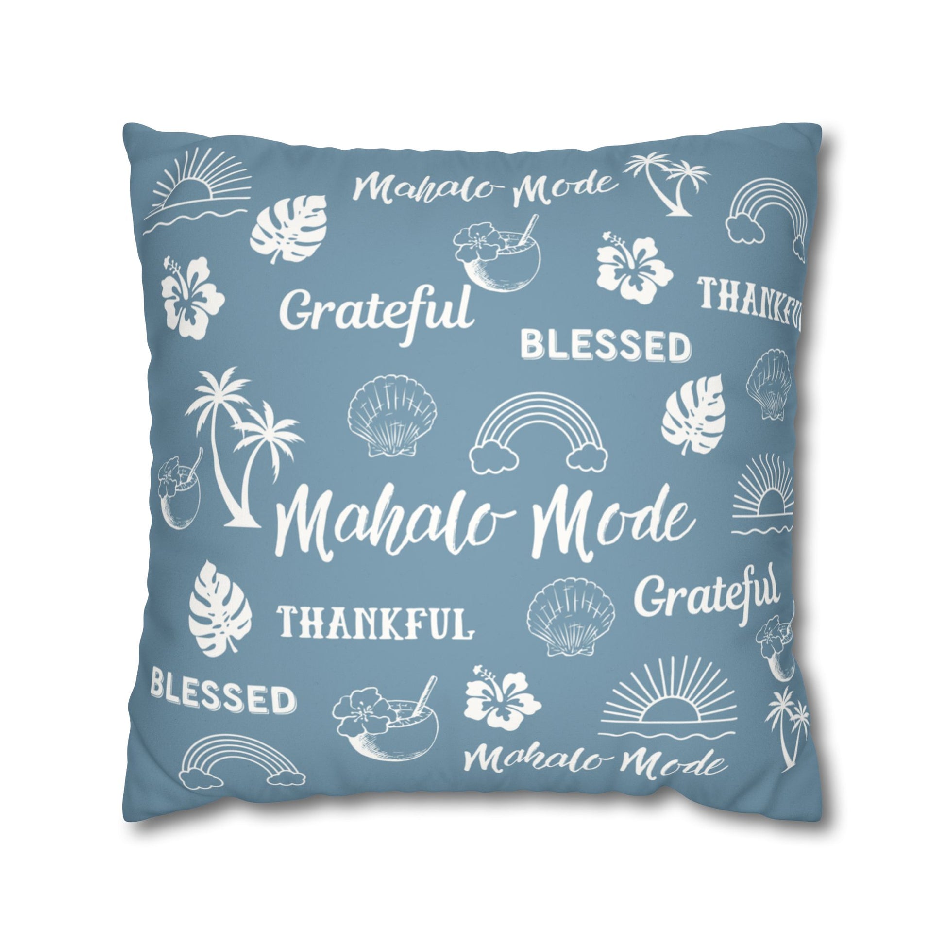 A square throw pillow in a dusty slate blue color, printed with white tropical-themed illustrations and words including 'Mahalo Mode', 'Grateful', 'Blessed', and 'Thankful'.