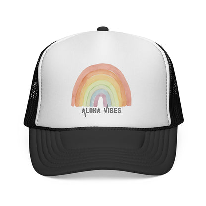 A black and white trucker hat featuring a pastel watercolor rainbow graphic on the front panel with the text 'ALOHA VIBES' underneath, shown against a plain white background.