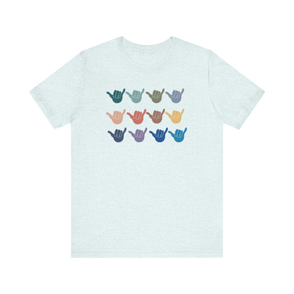 A light blue crewneck t-shirt featuring a graphic of nine shaka signs in various colors arranged in a 3x3 grid on the chest.