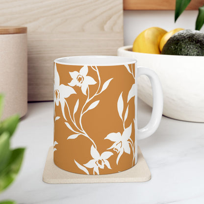 Orchid Caramel coffee mug with white tropical orchid print by Global Village Kailua sitting on  a coaster with a bowl of fruit.