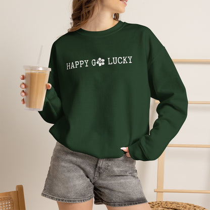 Person wearing a GREEN sweatshirt with text ʻHAPPY GO LUCKYʻ, holding a drink.
