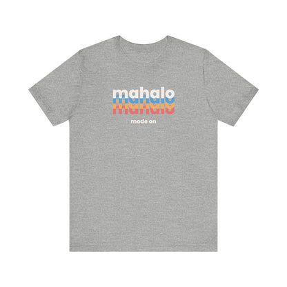 An athletic grey short-sleeve crewneck t-shirt with a retro-style chest graphic reading 'mahalo mode on' in white, blue, and orange lettering, displayed on a solid white background.