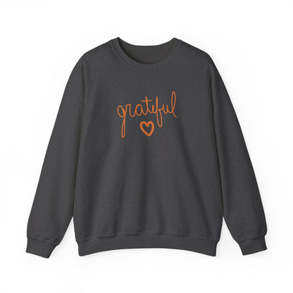 A dark grey crewneck sweatshirt featuring the word 'grateful' in orange cursive script and a matching orange heart outline on the chest, displayed against a solid white background.