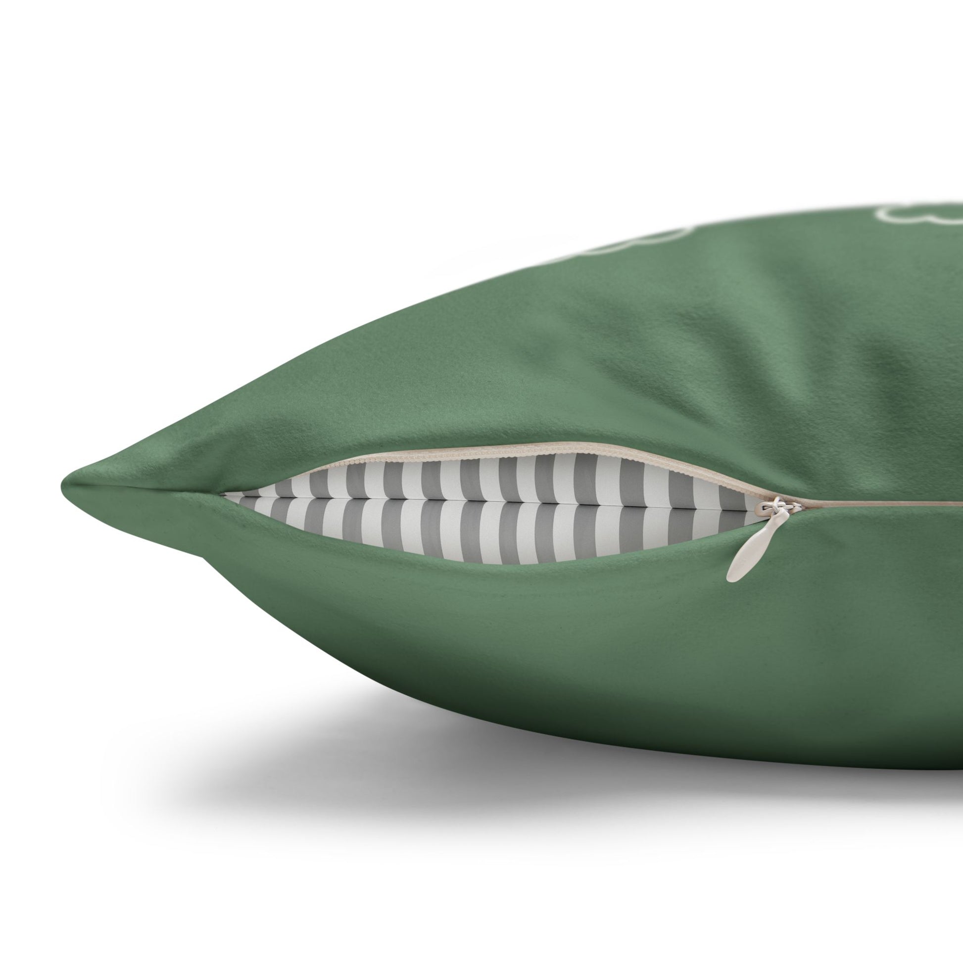 A close-up of a green throw pillow with a partially unzipped front, revealing a gray and white striped interior lining, on a white background.