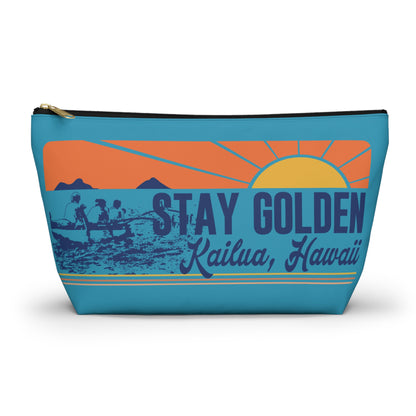A rectangular zippered pouch with a retro sunset graphic on a turquoise background. The design features an orange and yellow sun, mountains, a fishing scene, and the text 'STAY GOLDEN' and 'Kailua, Hawaii'.