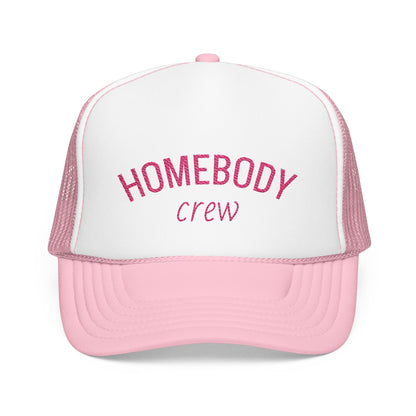 A pink and white trucker hat with 'HOMEBODY crew' embroidered on the front, shown against a plain white background.