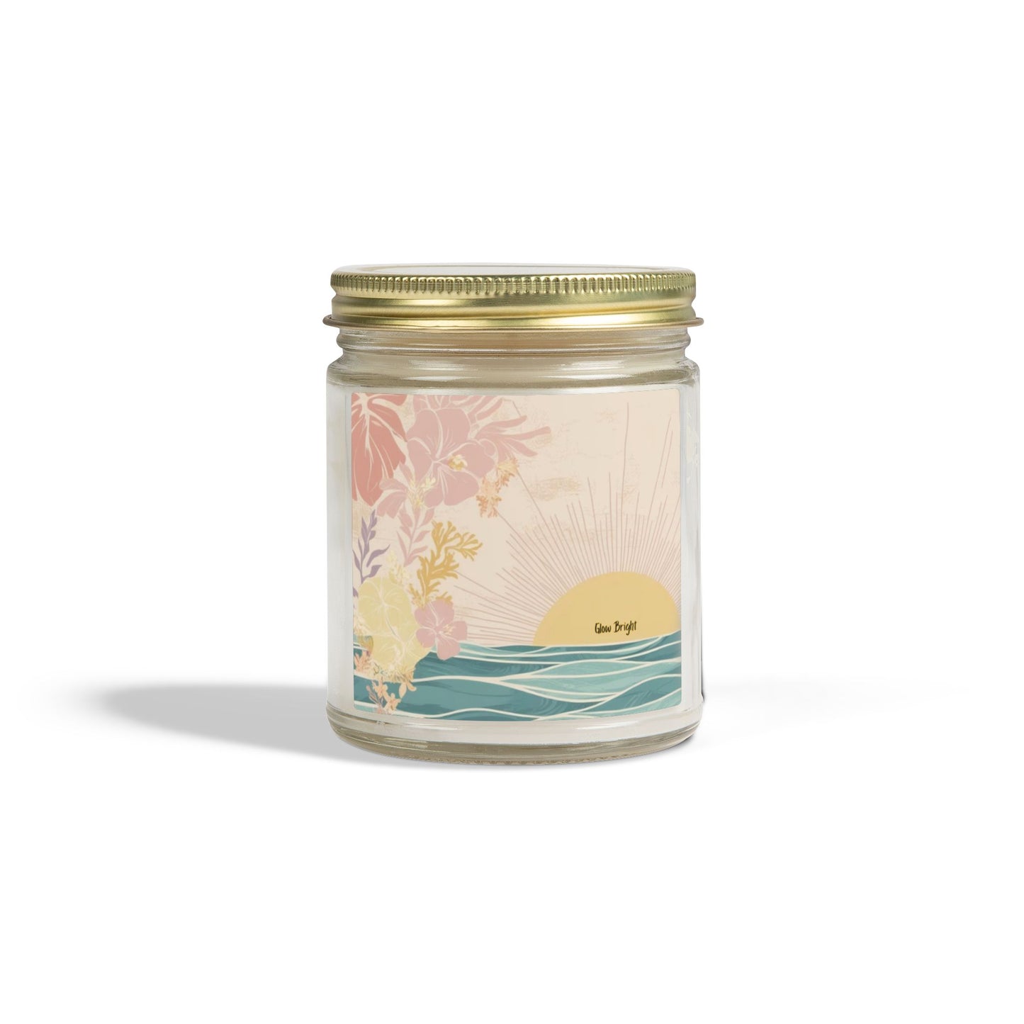 A glass jar candle with a gold metal screw-on lid and a pastel illustrated label depicting a sunset over waves with tropical flowers. The label has the text 'sea-breeze' on it.