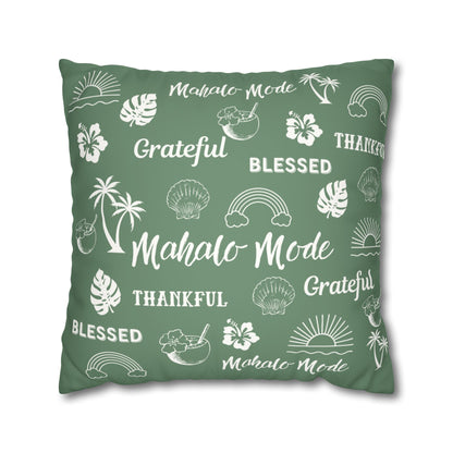A square sage green throw pillow featuring a white tropical-themed print with words like 'Mahalo Mode', 'Grateful', and 'Blessed' alongside palm trees, hibiscus flowers, seashells, rainbows, and sunsets, shown on a plain white background.