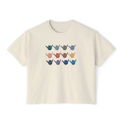 An off-white crop short-sleeve t-shirt with a graphic of twelve shaka signs in various colors arranged in three rows, displayed on a clean white background.