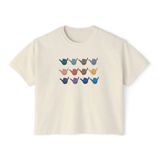 An off-white crop short-sleeve t-shirt with a graphic of twelve shaka signs in various colors arranged in three rows, displayed on a clean white background.