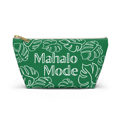 A green zippered pouch with a white tropical monstera leaf pattern and the words 'Mahalo Mode' printed in white on the front, featuring a gold zipper pull, set against a plain white background.