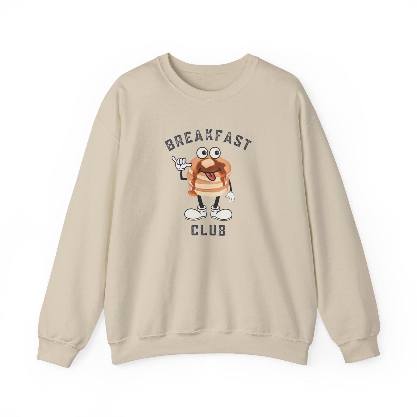 A sand crewneck sweatshirt featuring a cartoon graphic of a breakfast stack of pancakes character with the text 'BREAKFAST CLUB' printed on the front, displayed against a clean white background.