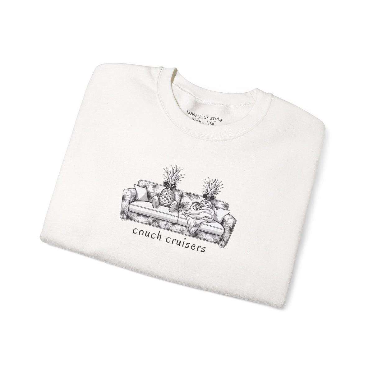 A folded white crewneck sweatshirt featuring a black line art graphic of a couch with pineapples and the text 'couch cruisers' underneath, displayed on a clean white background.